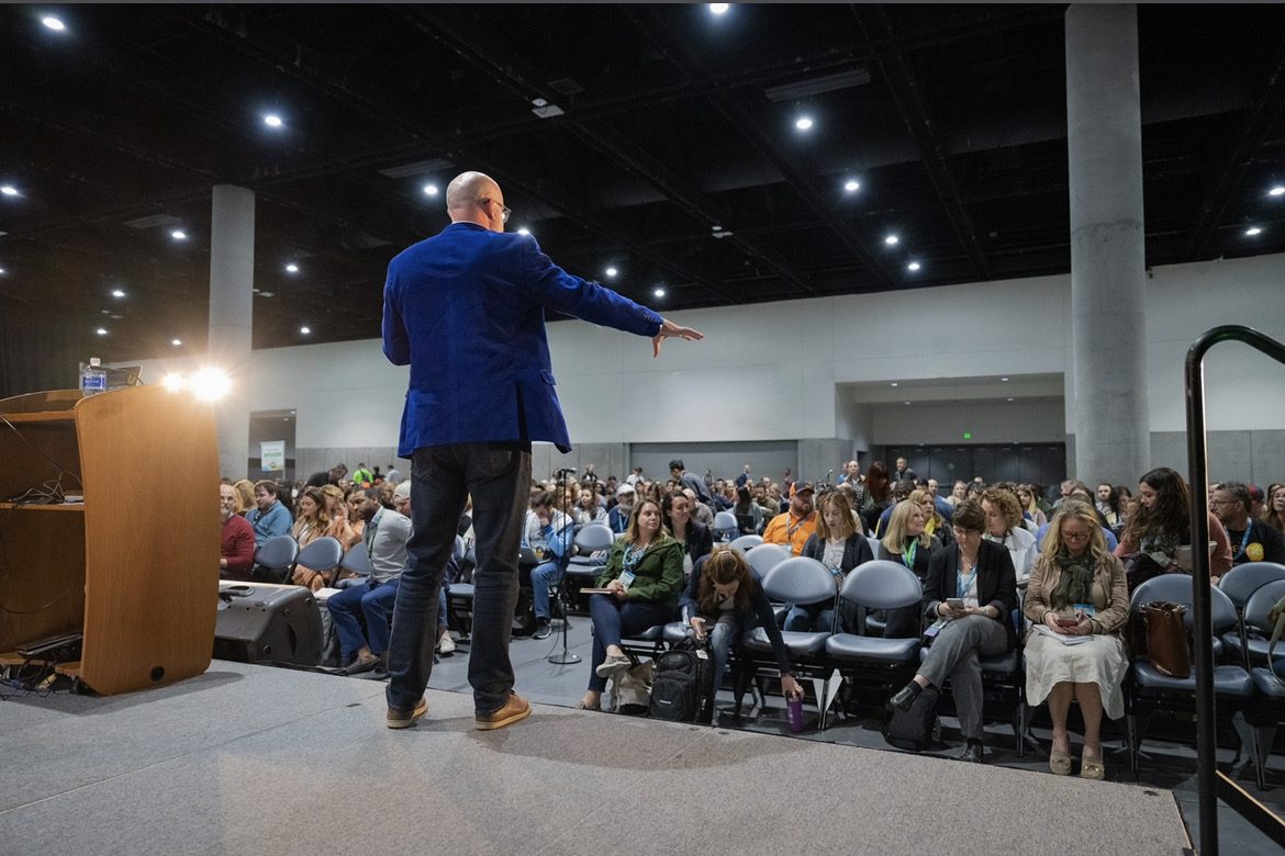 Angus Nelson speaking to large audience